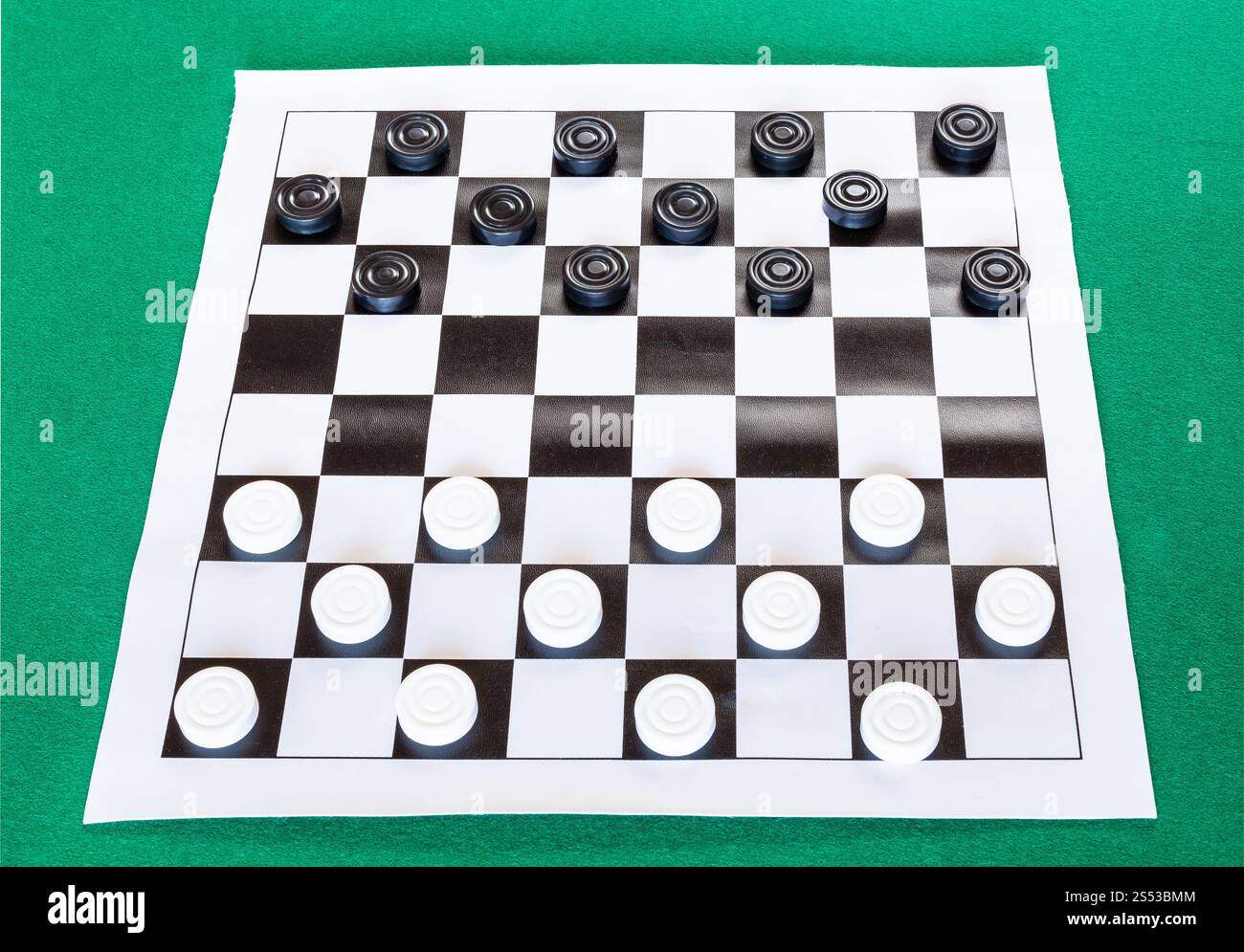 Kontrolleure auf schwarz-weiß karierten Blatt Board auf grünem Filz Tisch Stockfoto