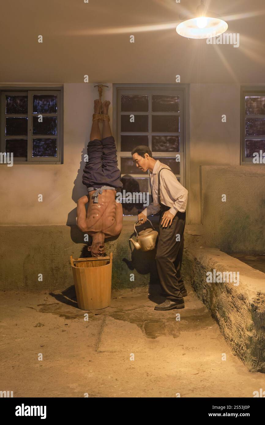 Eine Nachbildung der Folter mit einem Gefangenen, der kopfüber hängt, heißes Wasser in einem Eimer. Im Seodaemun Prison History Hall Museum in Seoul, Korea. Stockfoto