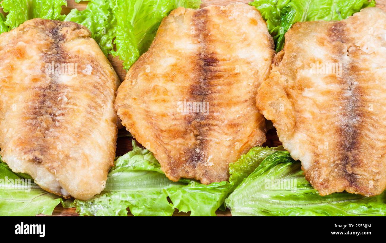Fried Barsch Filet auf grünem Salat Nahaufnahme Stockfoto