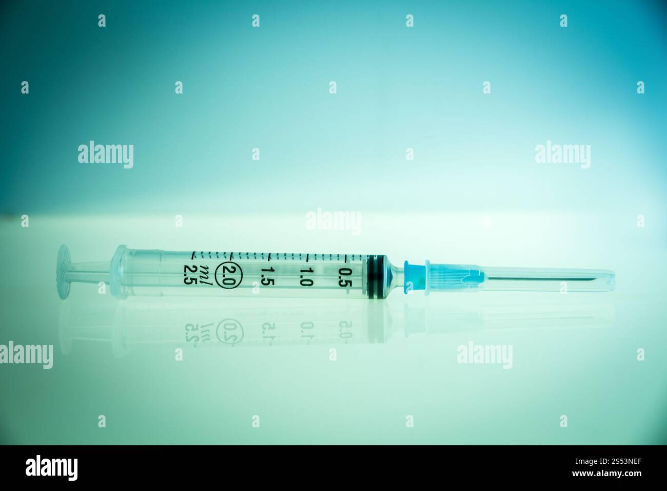Injektionsspritze auf einem sauberen blauen Hintergrund. Spritze auf blauem Hintergrund Stockfoto