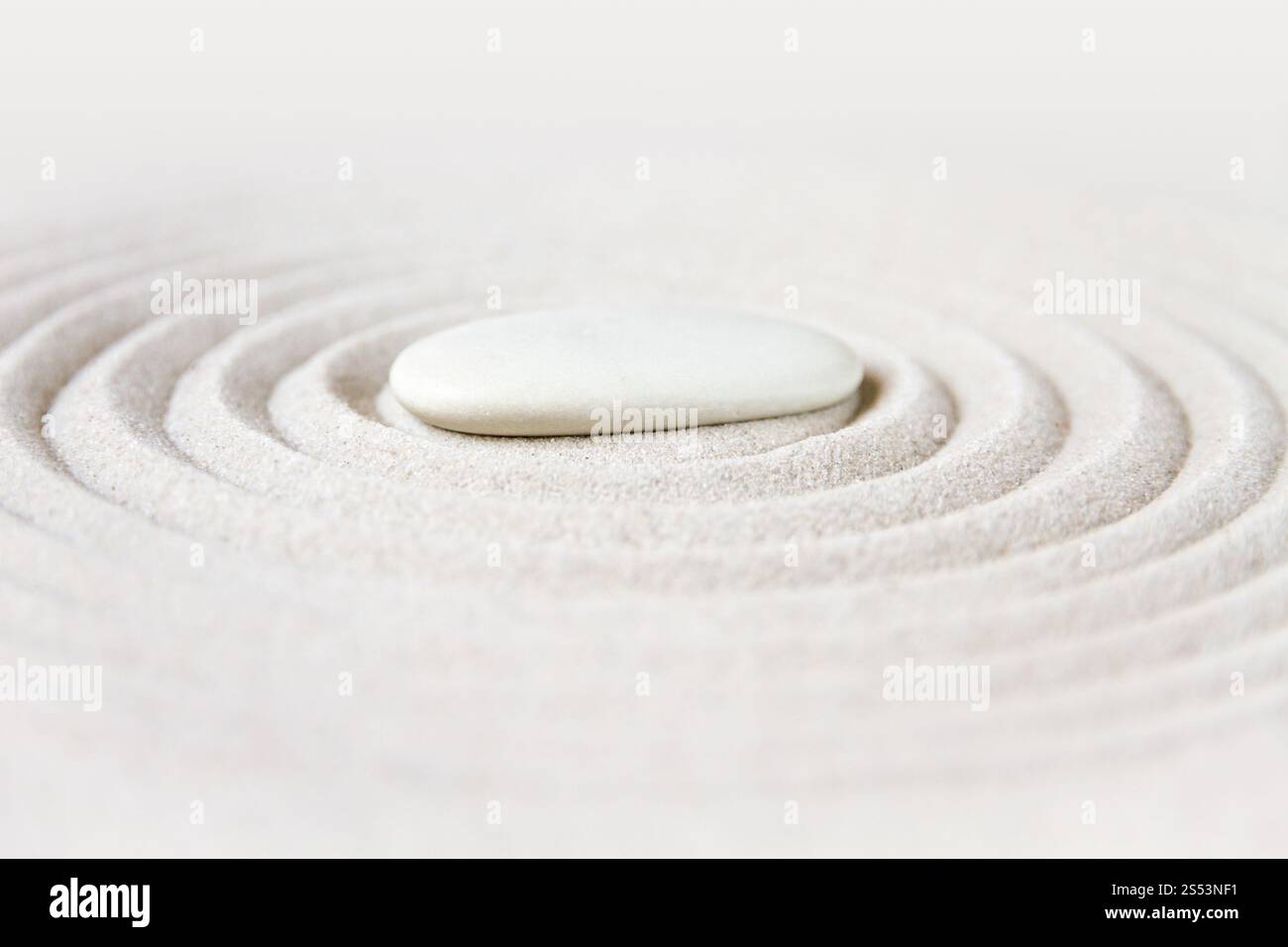 Weißer Stein im Sand. Zen-Hintergrundszene im japanischen Garten. Zen japanischer Garten Hintergrund Stockfoto