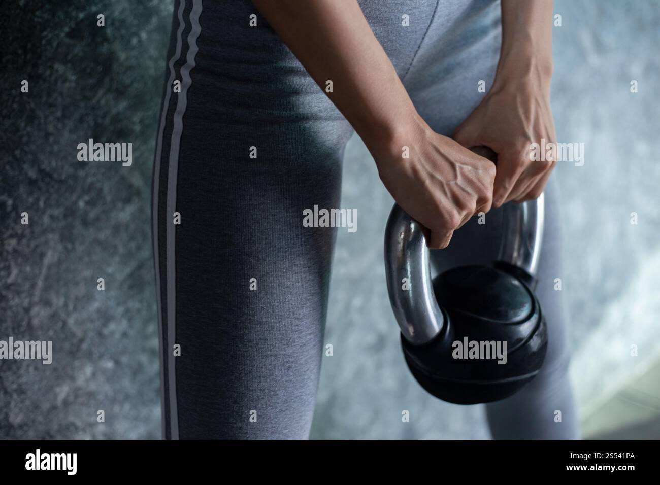 Asiatisches Mädchen, das mit der Kettlebell im Fitnessstudio trainiert. Stockfoto
