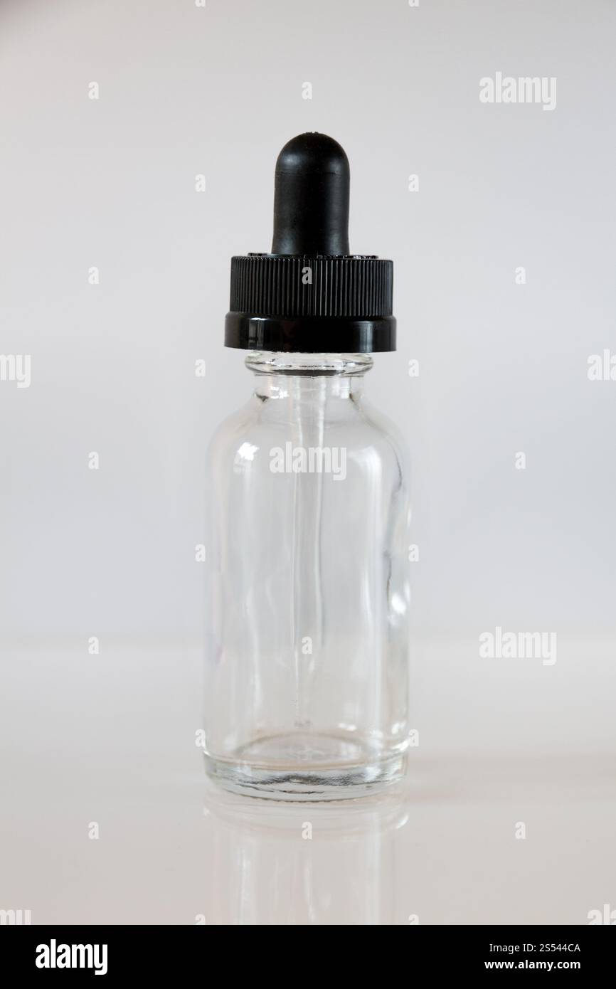 Tropfflasche aus Glas und Pipette auf grauem Hintergrund. Tropfflasche aus Glas auf grauem Hintergrund Stockfoto
