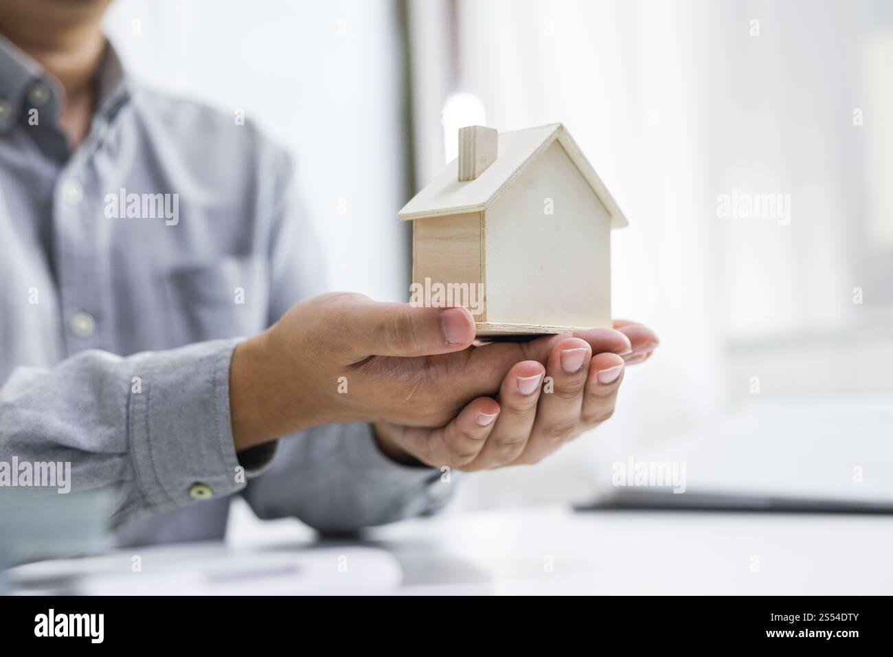 Immobilieninvestitionen Immobilienversicherung und -Sicherheit. Immobilienmakler bieten Haus an. Stockfoto