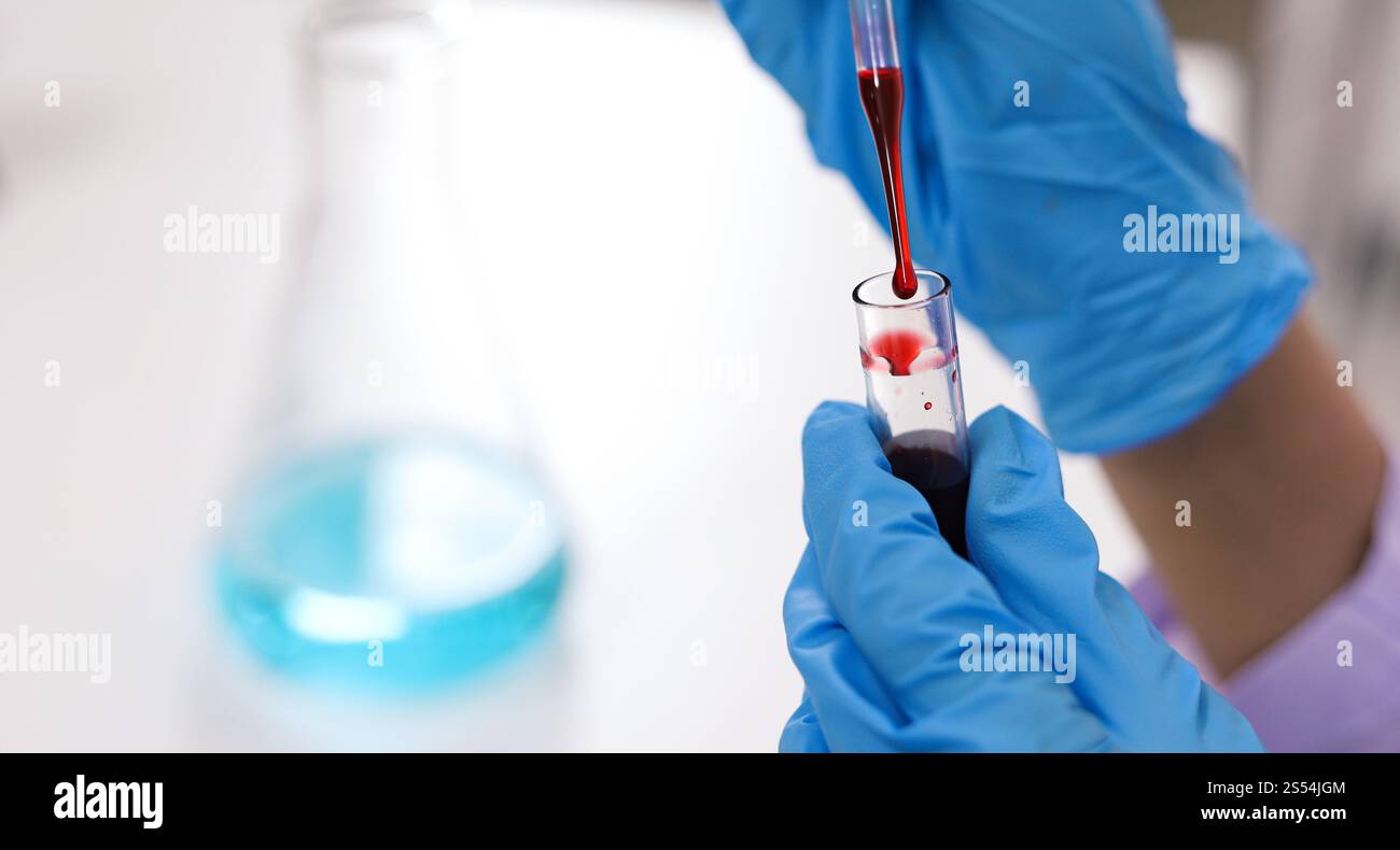 Wissenschaftler mit Coronavirus covid-19-infiziertem Blutprobenröhrchen. DNA-Testung des Blutes im Labor mit Blutentnahmeröhrchen und Stockfoto
