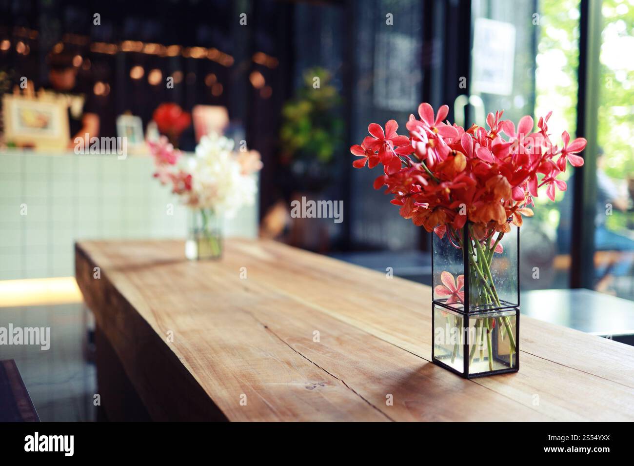 Rosa Blume in Vase steht auf dem Tisch in einem Café für Hintergrund Stockfoto