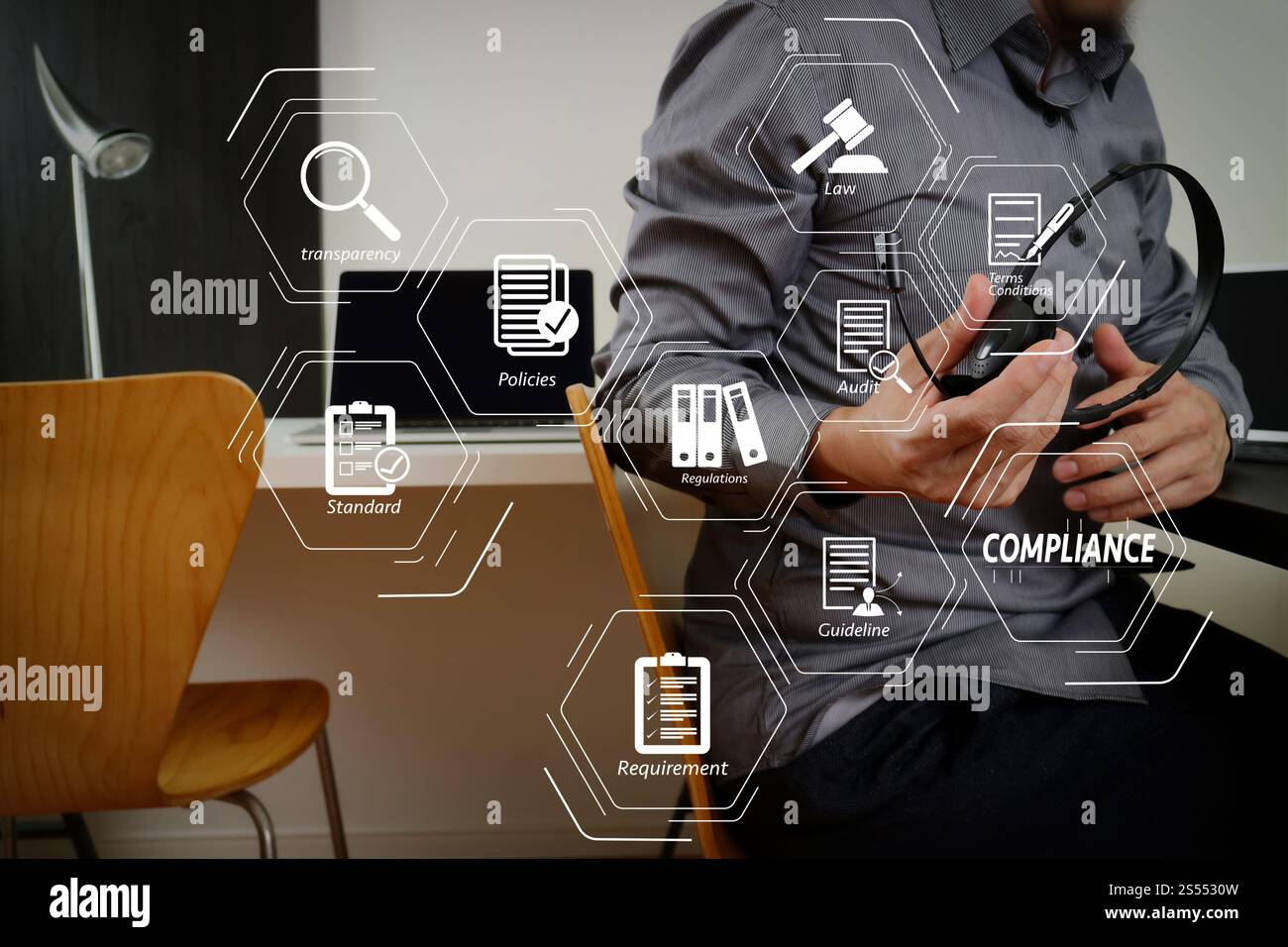 Virtuelles Diagramm zur Compliance für Vorschriften, Gesetze, Standards, Anforderungen und Audits. Mann mit VoIP-Headset mit digitalem Tablet und Laptop AS Stockfoto