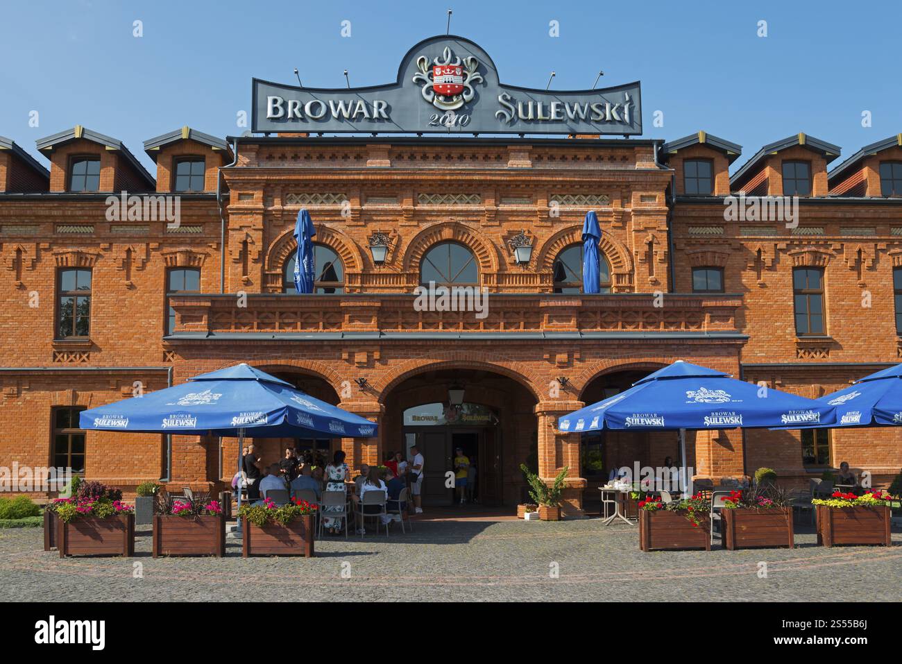 Eingangsbereich einer Brauerei mit blauen Sonnenschirmen vor einem Backsteingebäude, Sulewski-Brauerei, Hrubieszow, Hrubieszow, Powiat Hrubieszowski, Lublin Vo Stockfoto