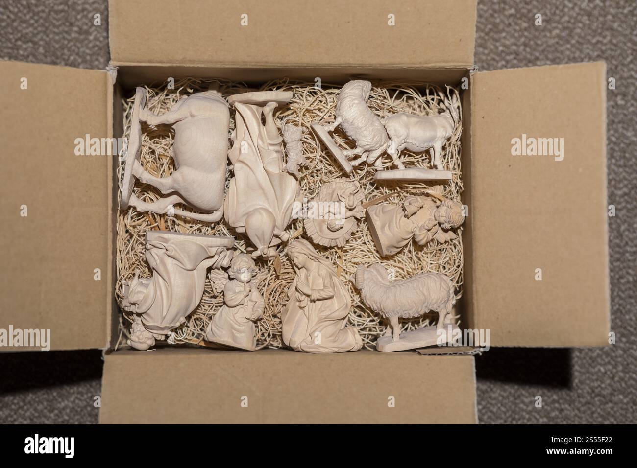 Krippenfiguren aus Holz, in Strohwolle gewickelt, in einer Kiste, die auf das nächste Weihnachten wartet Stockfoto