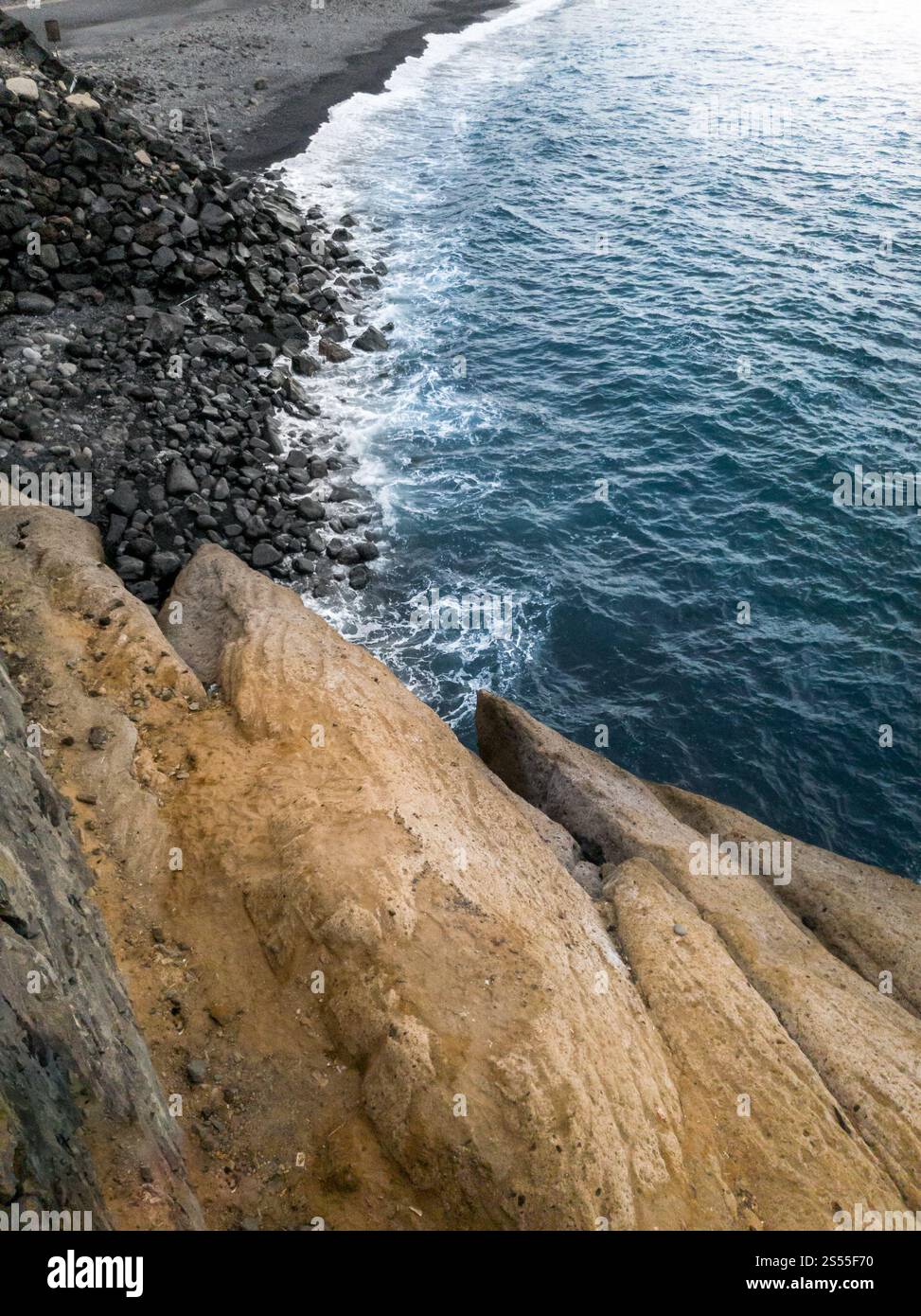 Wunderschöne Landschaft mit ruhigen Meereswellen, scharfen Klippen und schwarzem vulkanischem Sand am Strand. Wunderschöne Landschaft mit ruhigen Meereswellen, scharfen Klippen und Stockfoto Wunderschöne Landschaft mit ruhigen Meereswellen, scharfen Klippen und schwarzem vulkanischem Sand am Strand. Wunderschöne Landschaft mit ruhigen Meereswellen, scharfen Klippen und Stockfoto