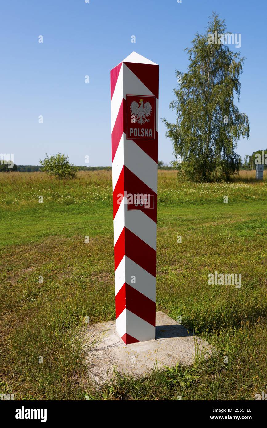Polnischer rot-weißer Grenzposten auf einer grünen Wiese unter sonnigem Himmel, Grenze zur Ukraine, Beresnica, Dorohusk, HorodNo, Horodlo, Hrubies Stockfoto