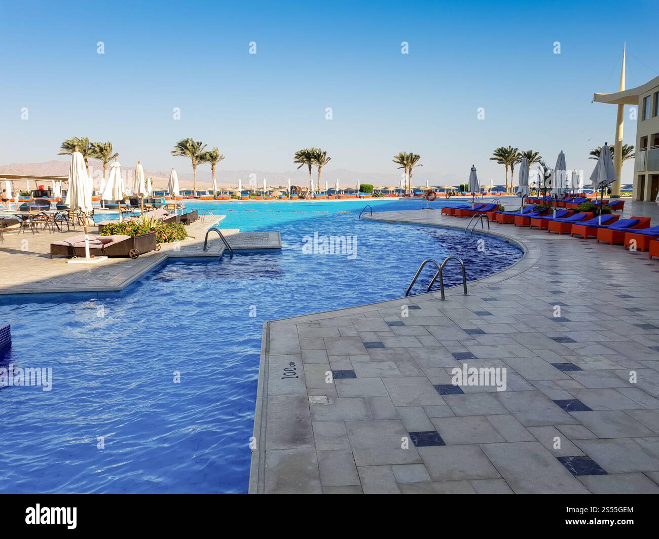 Swimmingpool mit vielen Sonnenliegen im Sommerstrand Hotel Resort. Outdoor Swimmingpool mit vielen Sonnenliegen im Sommerstrand Hotel Resort Stockfoto