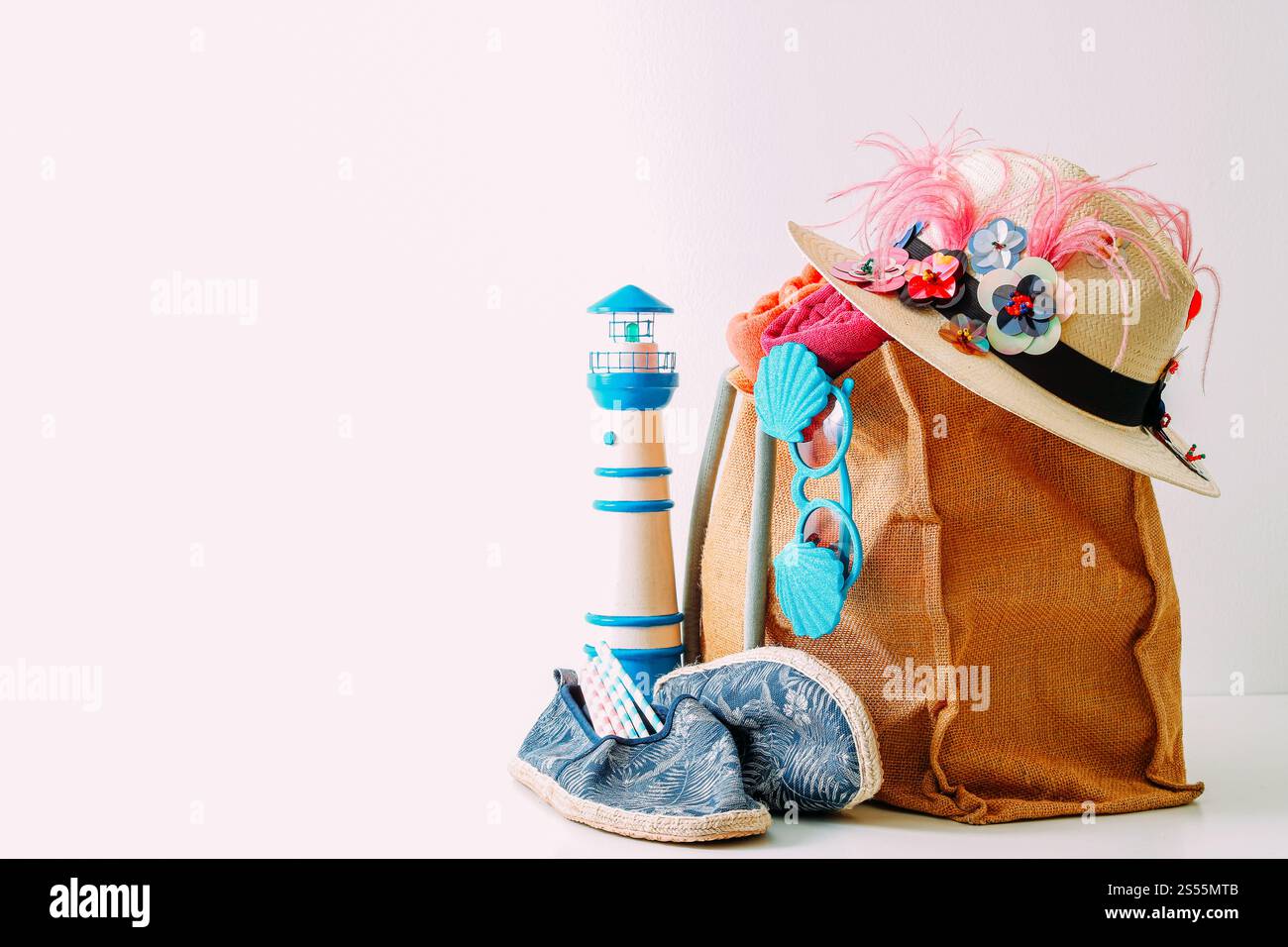 Reisekonzept für Sommerurlaub. Hipster-Strandtasche mit Artikeln für einen Tag am Meer auf weißem Hintergrund Stockfoto