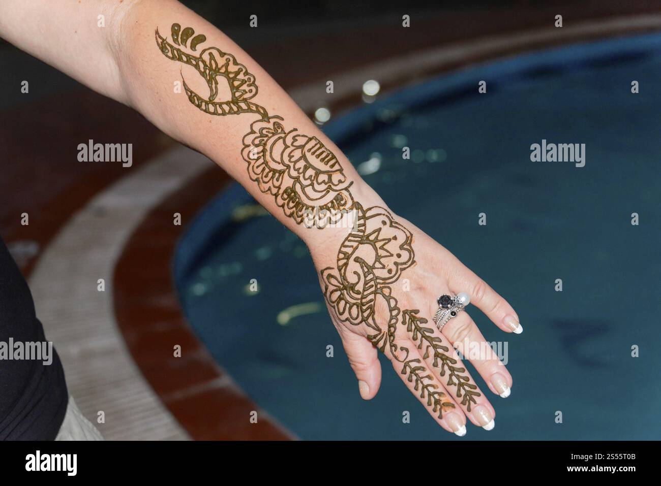 Kovalam Beach, Südindien, Indien, Asien, Arm mit verzierten Henna-Mustern am Handgelenk und an den Fingern über einem Pool, Kovalam, Malabar Coast, Malabar, Kerala, Asien Stockfoto