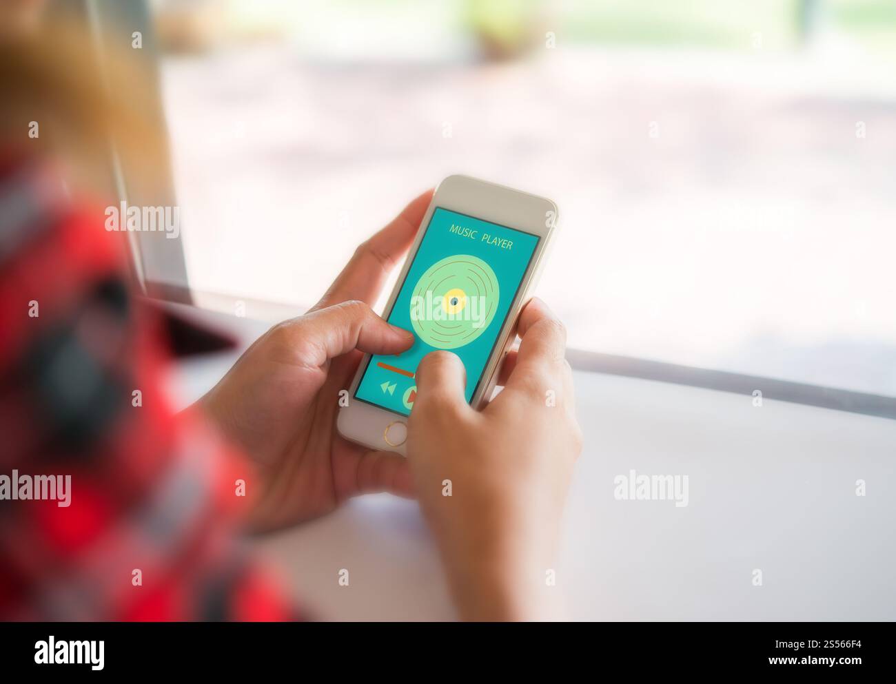 Frau Hände halten Smartphones mit dem Music Player auf dem Bildschirm, während der Sitzung im Cafe. Stockfoto