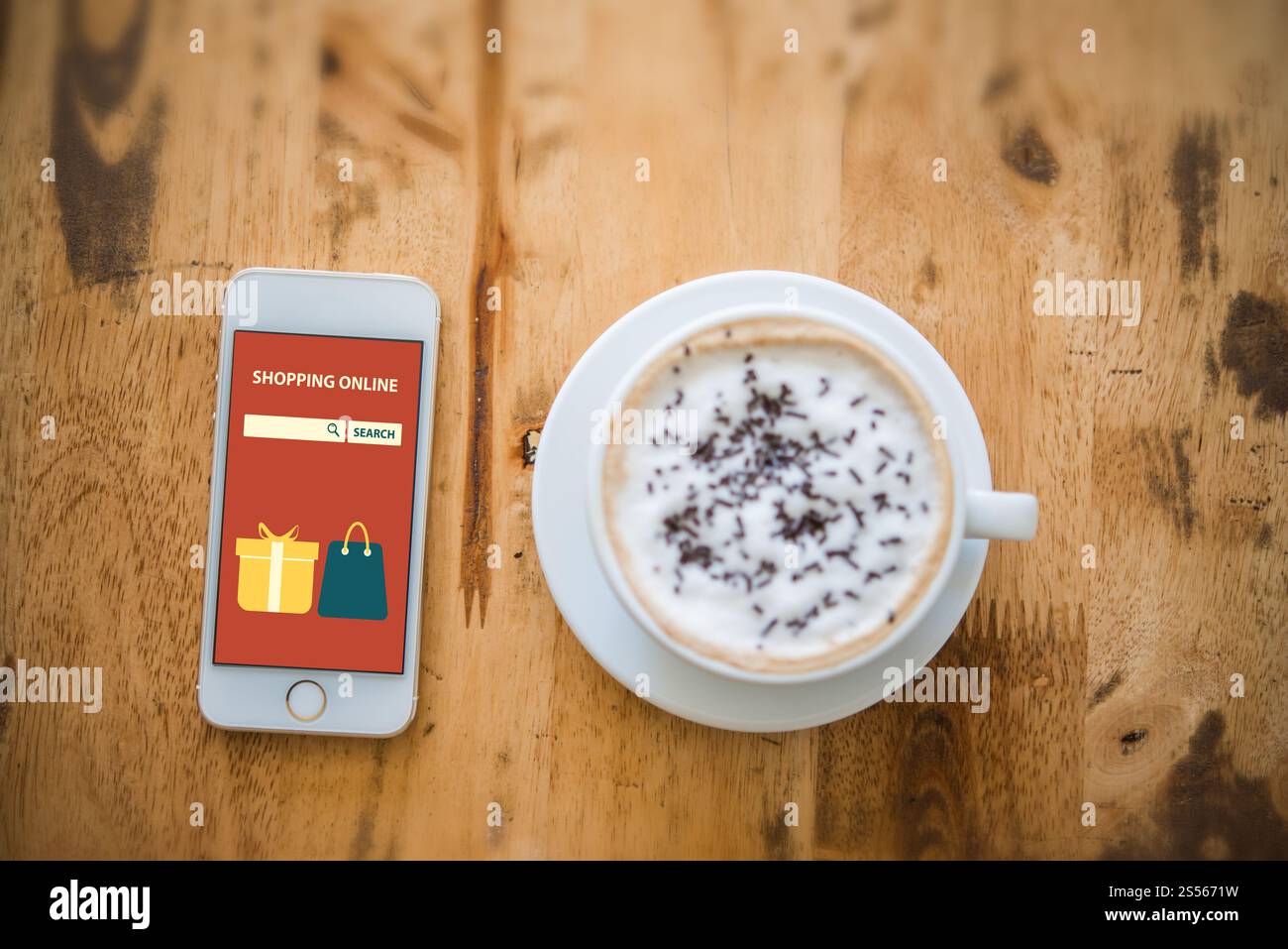 Mit dem on-line-Einkaufen auf dem Bildschirm in der Nähe der Tasse Kaffee auf holztisch Smartphone. Stockfoto