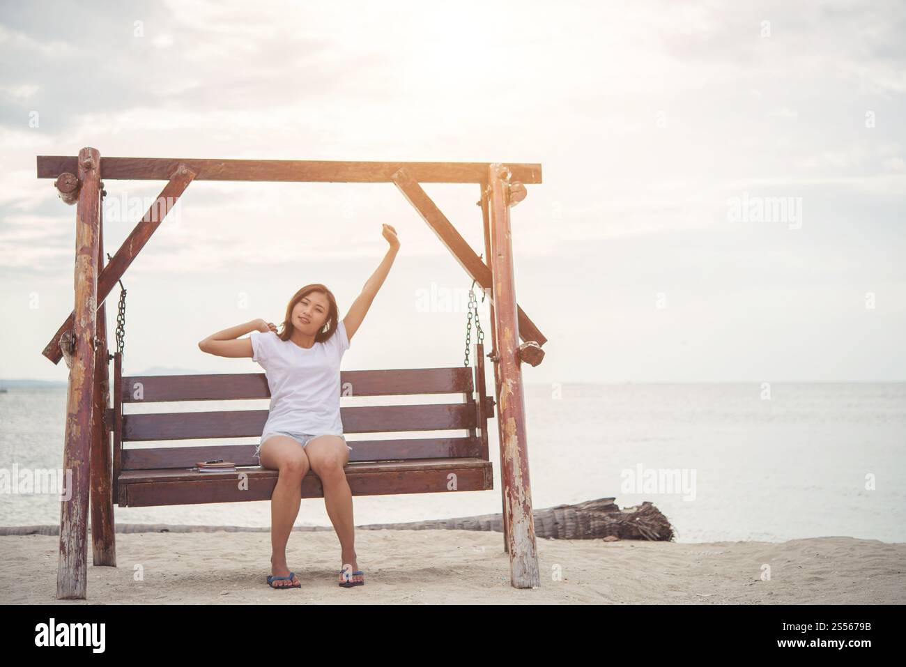Schöne Frau stretching auf einer Schaukel am Strand. Stockfoto