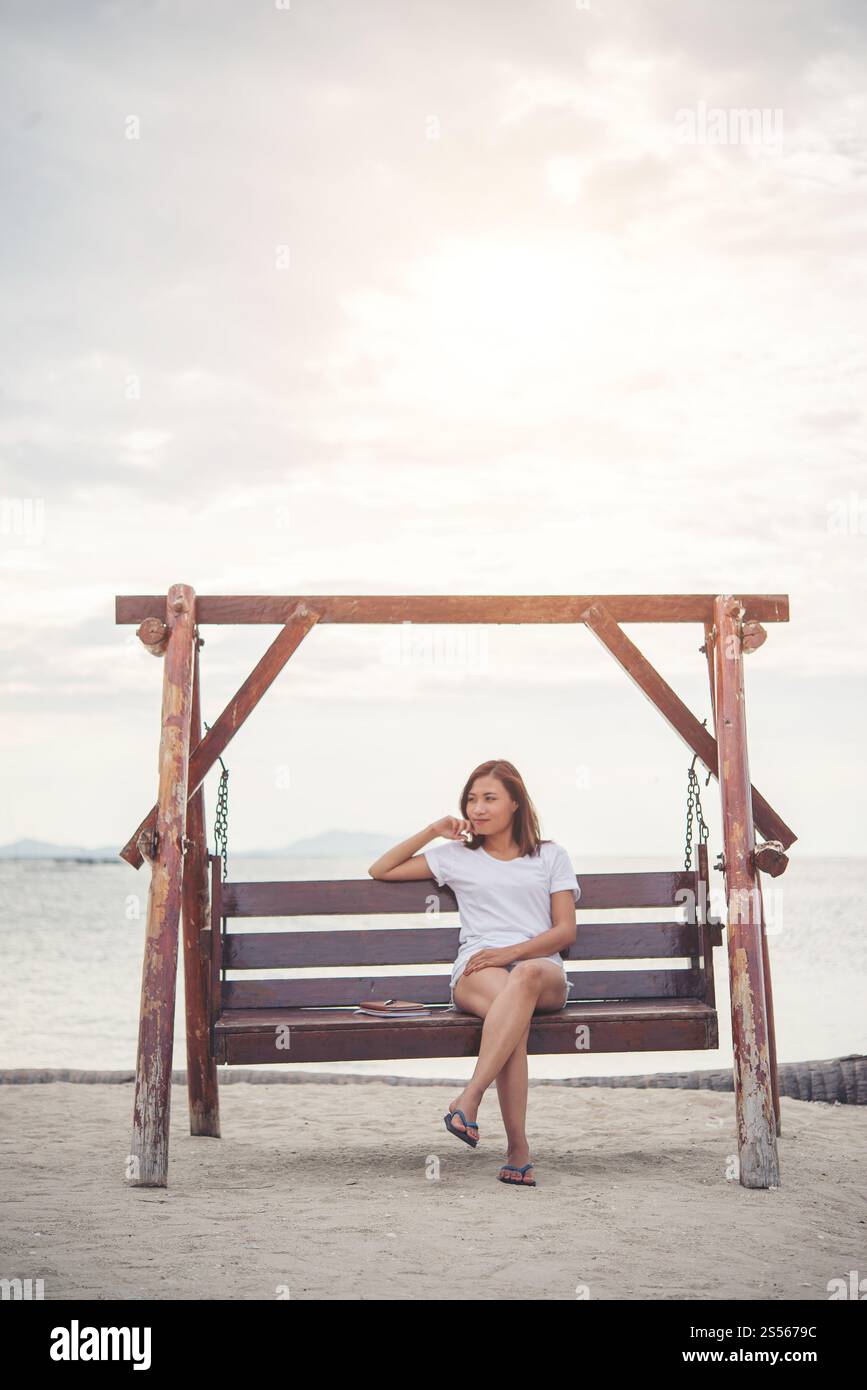 Schöne Frau stretching auf einer Schaukel am Strand. Stockfoto
