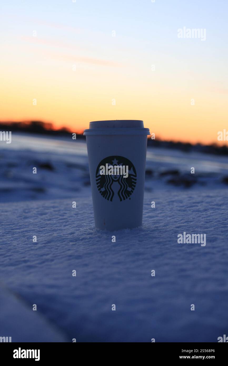 Starbucks Cup im verschneiten Sonnenuntergang Stockfoto