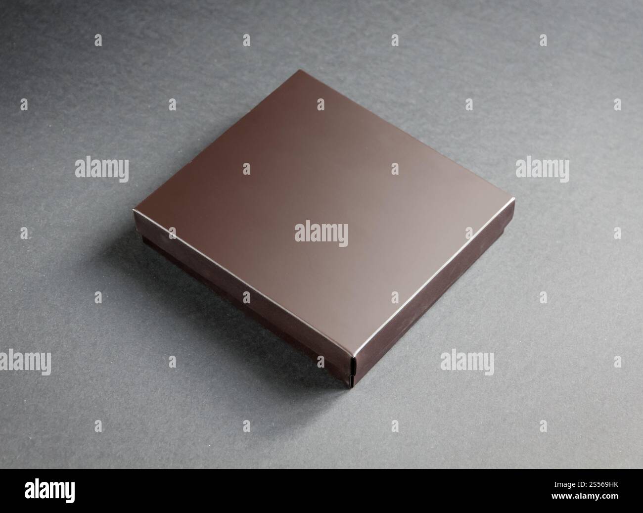 Schwarze luxuriöse Geschenkbox mit goldenem Band auf schwarzem Hintergrund. Schwarze Geschenkbox mit goldenem Band auf schwarzem Hintergrund Stockfoto