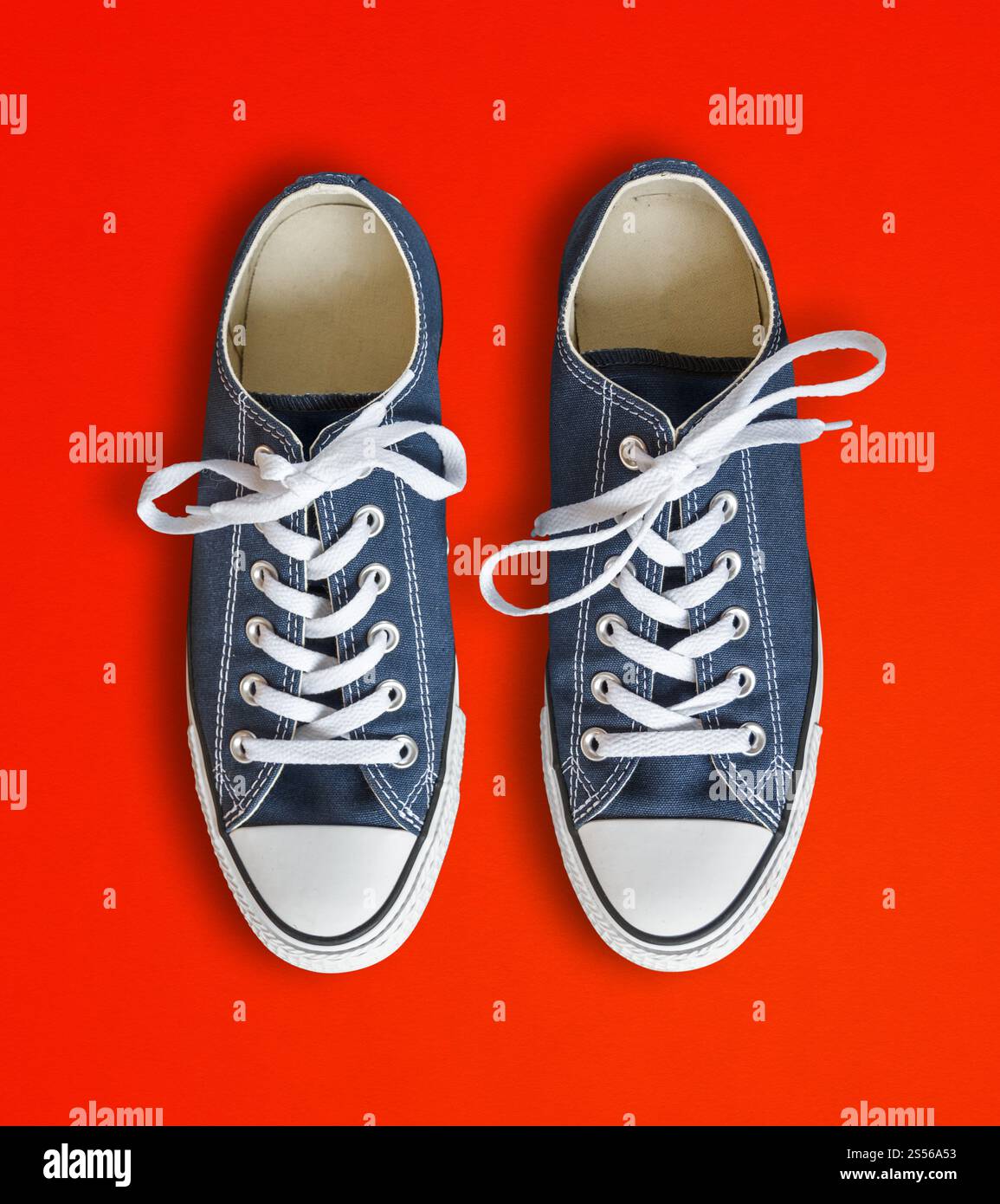 Blaue Sneakers auf rotem Hintergrund. Blaue Sneakers auf rotem Hintergrund Stockfoto