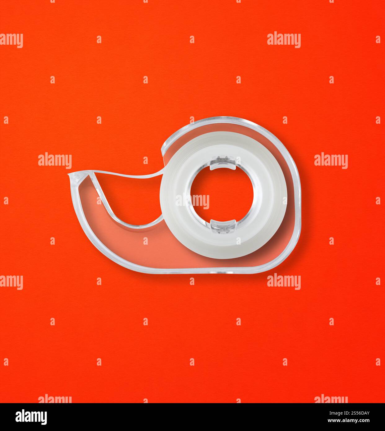 Transparenter Abroller mit Scotch-Klebeband, isoliert auf rotem Hintergrund. Scotch Tape Spender isoliert auf rotem Hintergrund Stockfoto