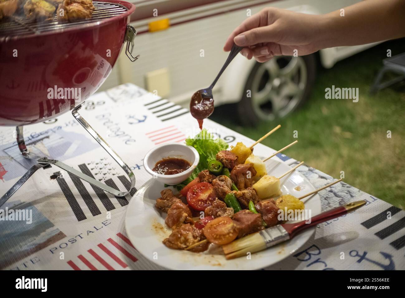 Freunde machen Barbecue BBQ Grillen über einem heißen Feuer in der Natur. Abendparty Stockfoto