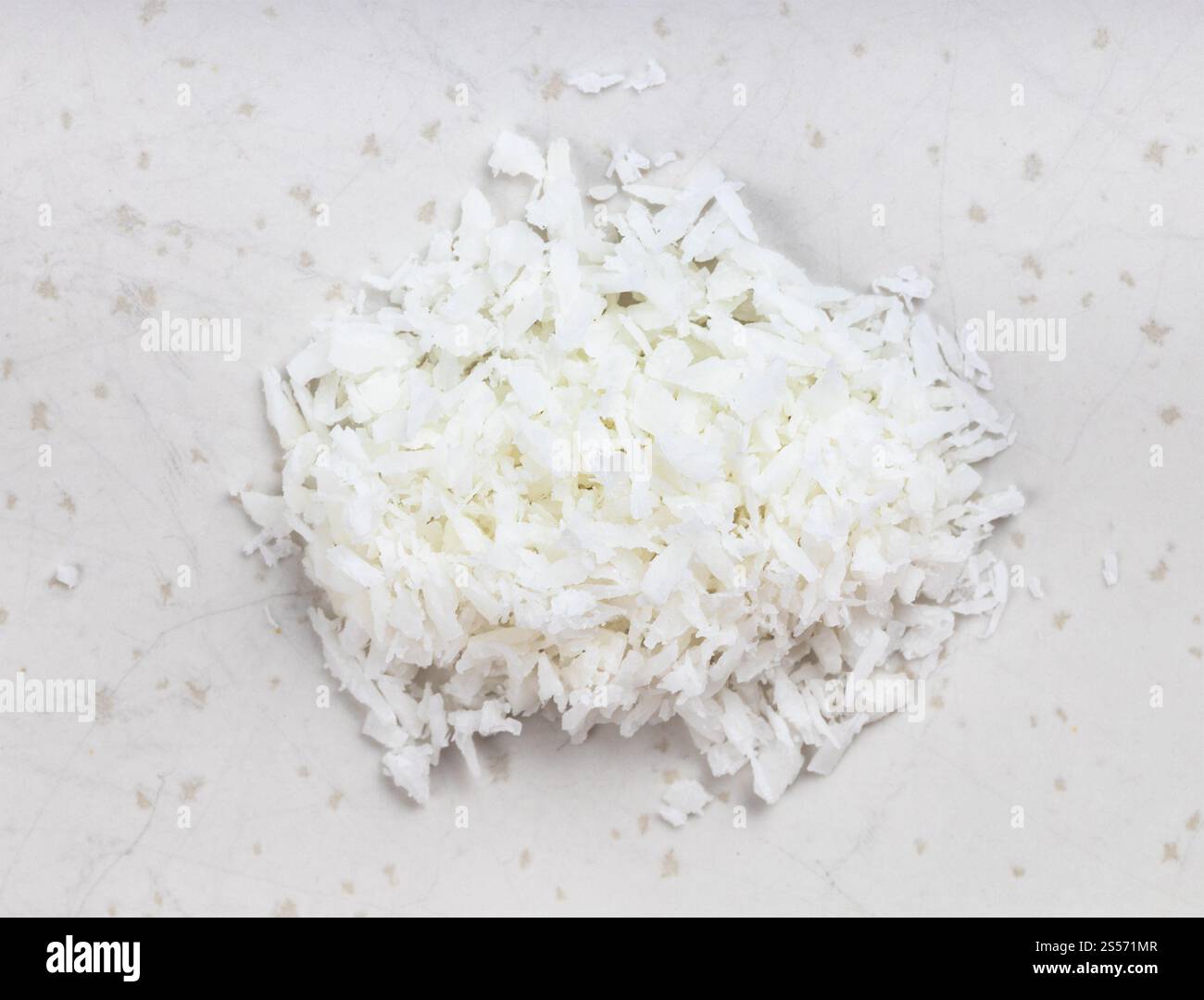 Draufsicht auf den Haufen Kokosflocken aus nächster Nähe Graue Keramikplatte Stockfoto