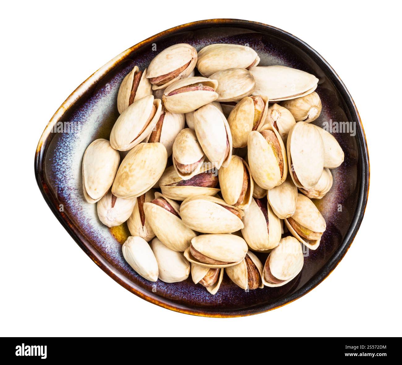 Draufsicht auf rohe reife Pistazien in Keramikschale Isoliert auf weißem Hintergrund Stockfoto