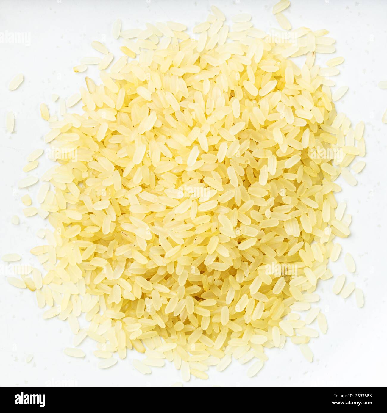 Draufsicht auf den Haufen rohen, parboiled Reises aus nächster Nähe Auf grauer Keramikplatte Stockfoto