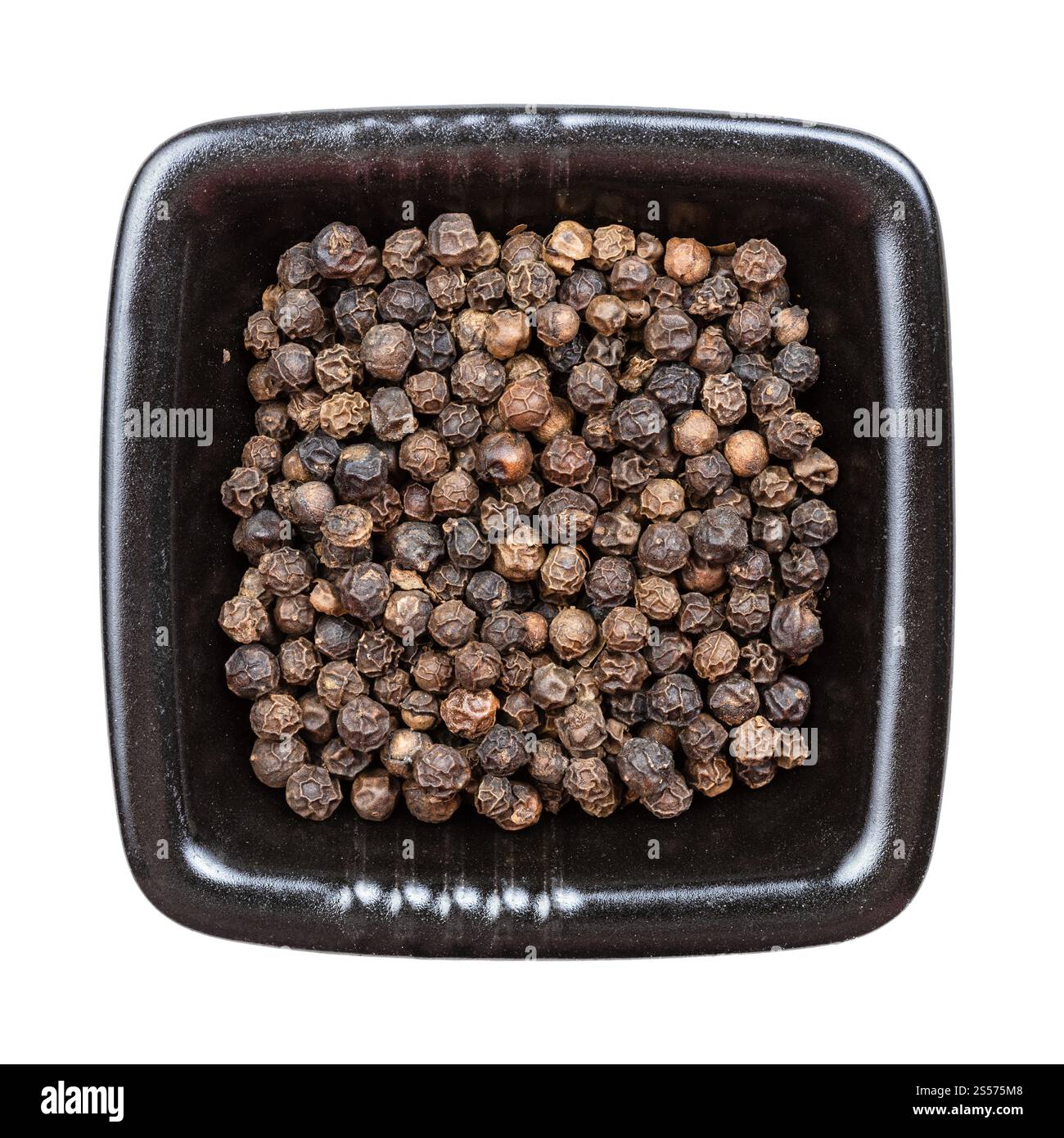 Draufsicht auf hainan schwarzen Pfeffer in schwarzer Schüssel isoliert Auf weißen Hintergrunsen Stockfoto