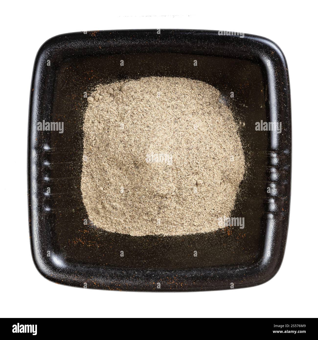 Draufsicht auf gemahlenen schwarzen Pfeffer in schwarzer Schüssel isoliert Auf weißem Hintergrund Stockfoto