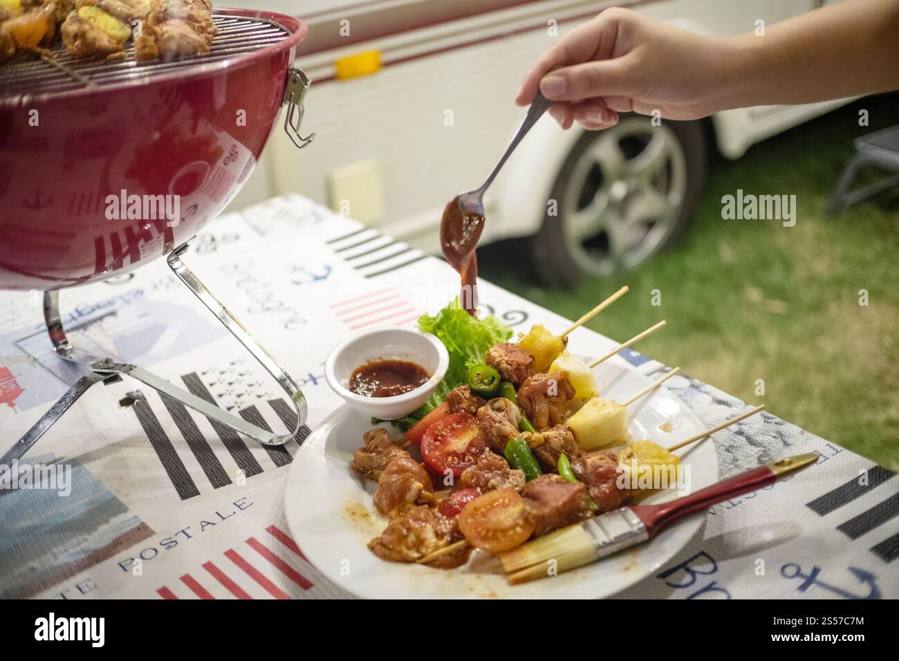 Freunde machen Barbecue BBQ Grillen über einem heißen Feuer in der Natur. Abendparty Stockfoto