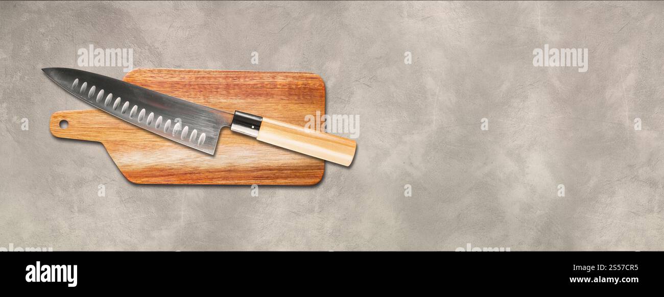 Traditionelles japanisches gyuto Chefmesser auf einem Schneidebrett. Banner mit hellem Beton-Hintergrund Stockfoto