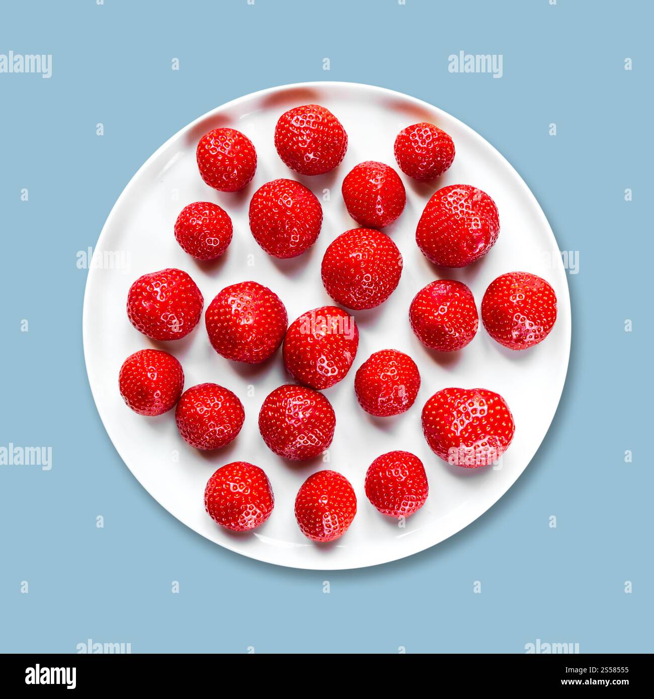 Erdbeeren in einem Teller isoliert auf grauem Hintergrund. Erdbeeren auf einem Teller. Grauer Hintergrund Stockfoto