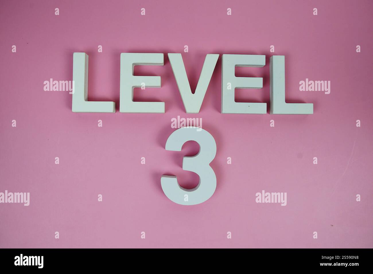 Ebene 3 Ebene 3 Buchstaben mit Buchstaben auf rosa Hintergrund Stockfoto