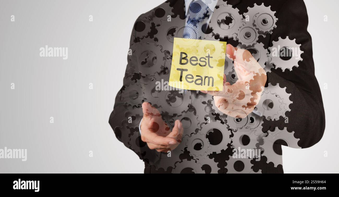 Geschäftsmann Hand zeigen beste Team Wörter auf Zettel mit abstrakten Zahnrad-Getriebe als Konzept Stockfoto