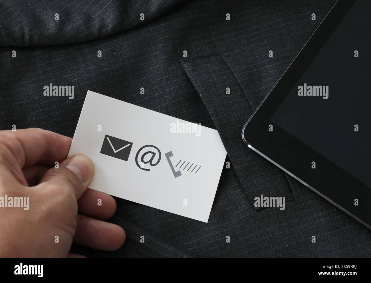 Nahaufnahme des Geschäftsmannes Hand Picking Visitenkarte Icon Kontaktieren Sie uns Konzept aus der Tasche des grauen Anzug Jacke Hintergrund Stockfoto
