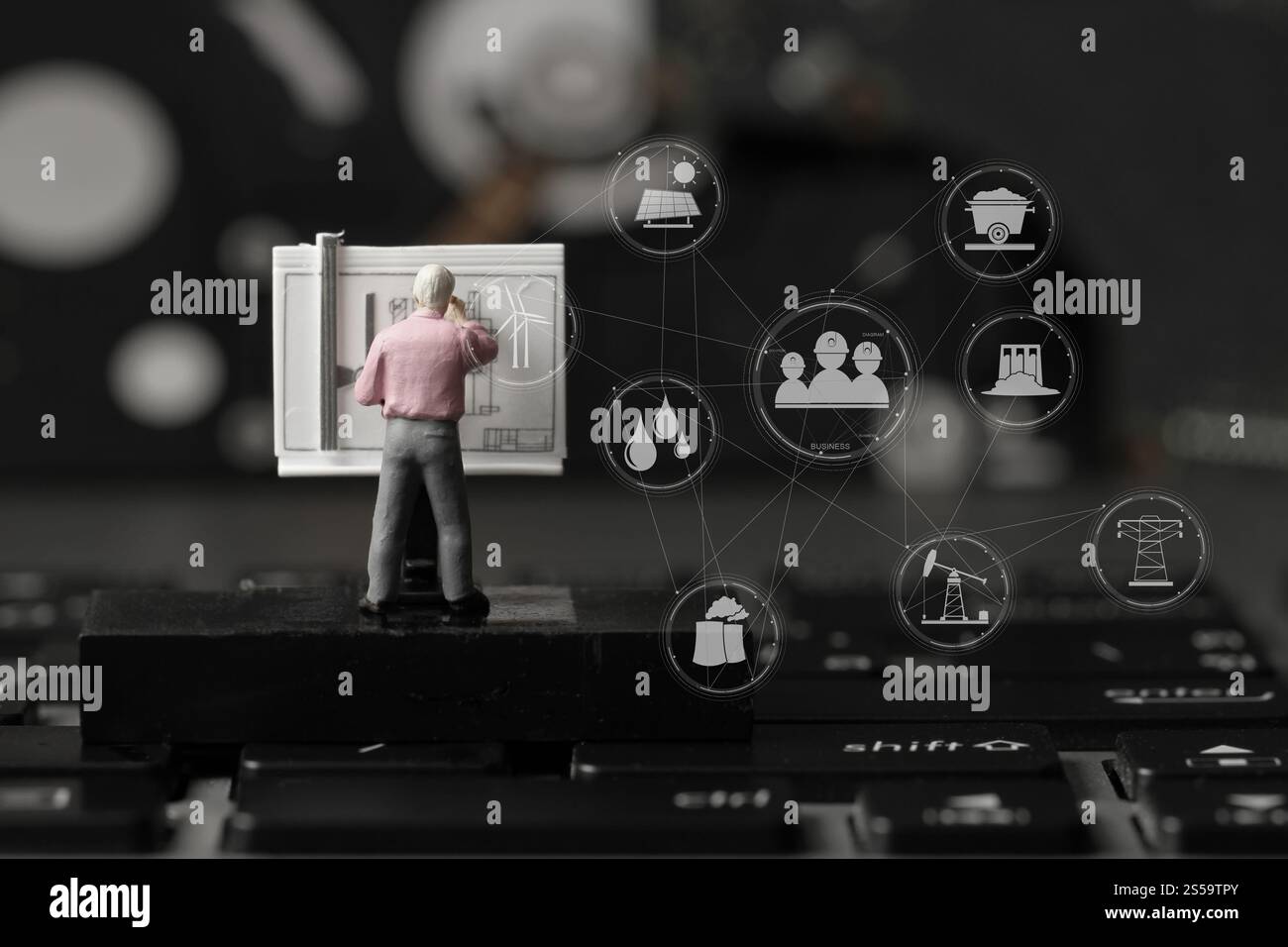 Industriekonzept-Miniaturingenieur, der mit einem Zeichentisch auf einem Laptop mit Industriediagramm arbeitet Stockfoto