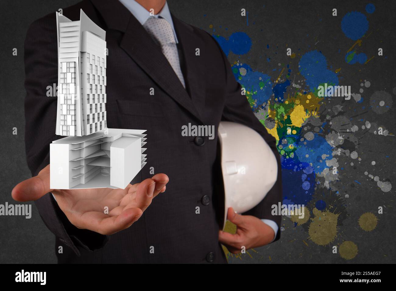 Geschäftsmann Hand präsentiert Bebauung und Splash Farben als Konzept Stockfoto