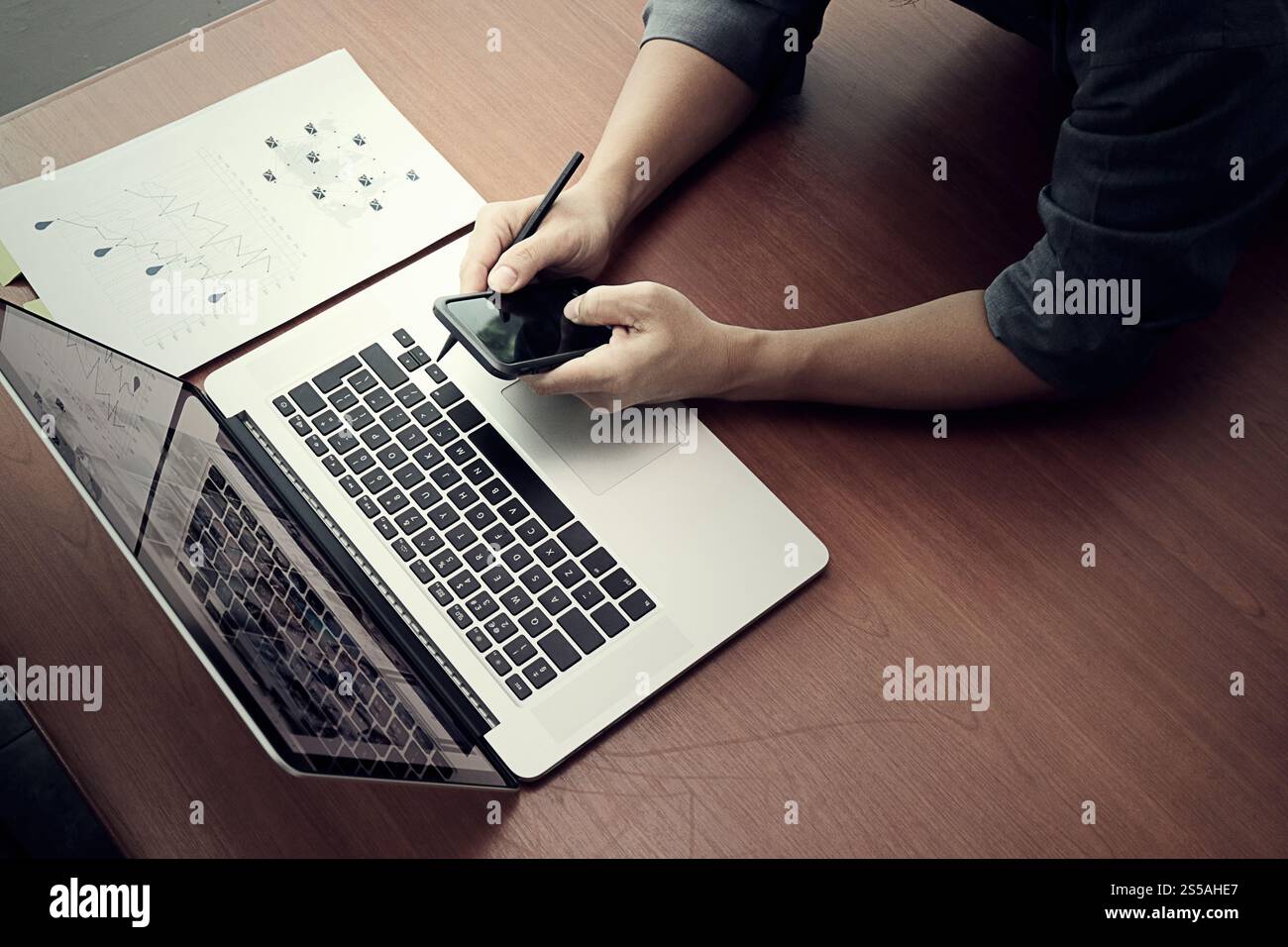 Draufsicht der Geschäftsmann Hand arbeiten mit neuen modernen Computer und Smartphone und Geschäftsstrategie auf hölzernen Schreibtisch als Konzept Stockfoto