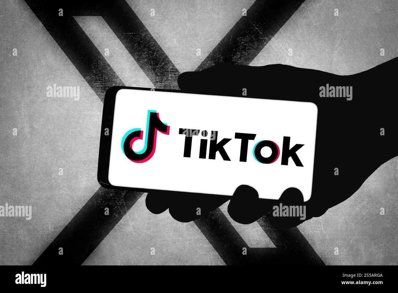 Das TikTok-Logo wird auf dem Smartphone mit dem X-Logo im Hintergrund angezeigt Stockfoto