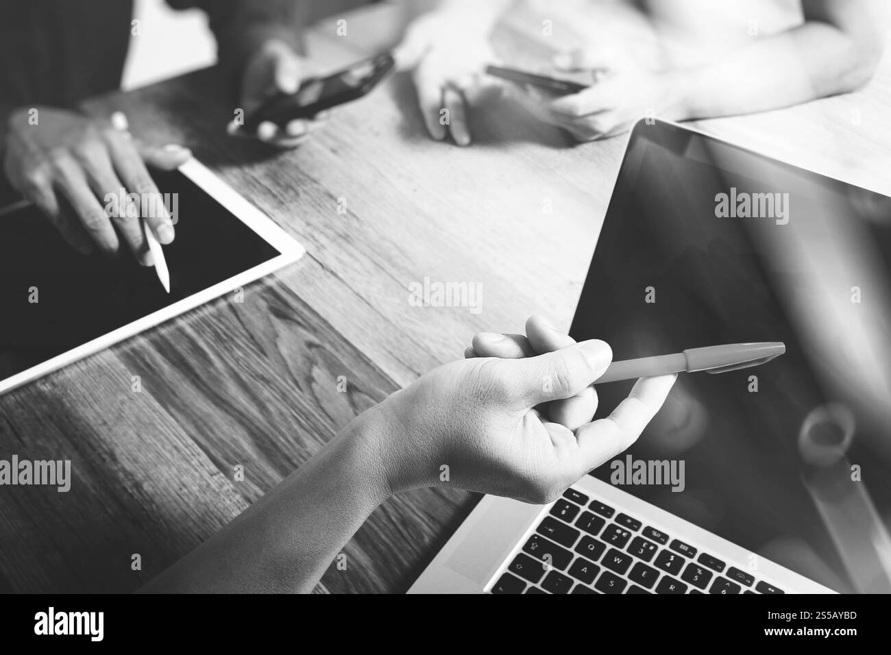 Teamwork-Konzept, Geschäftsmann Hand besucht Videokonferenz in modernem Büro. Digitales Tablet Laptop Computer Design Smartphone mit, schwarz weiß Stockfoto