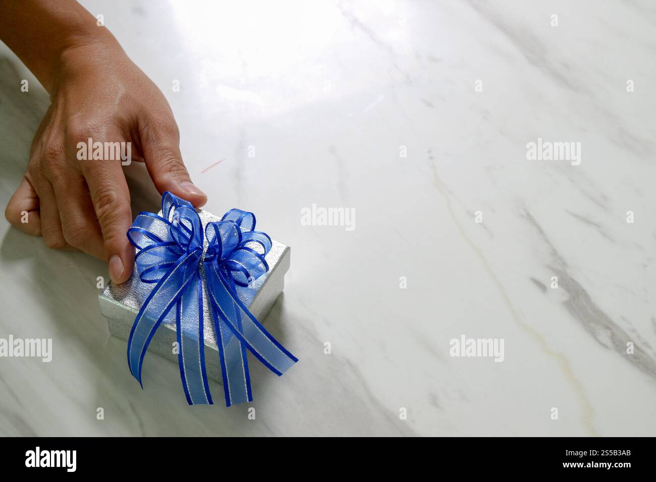 Geschenke, Mann Hand hält eine Geschenkbox in einer Geste der giving.blurred Hintergrund Stockfoto