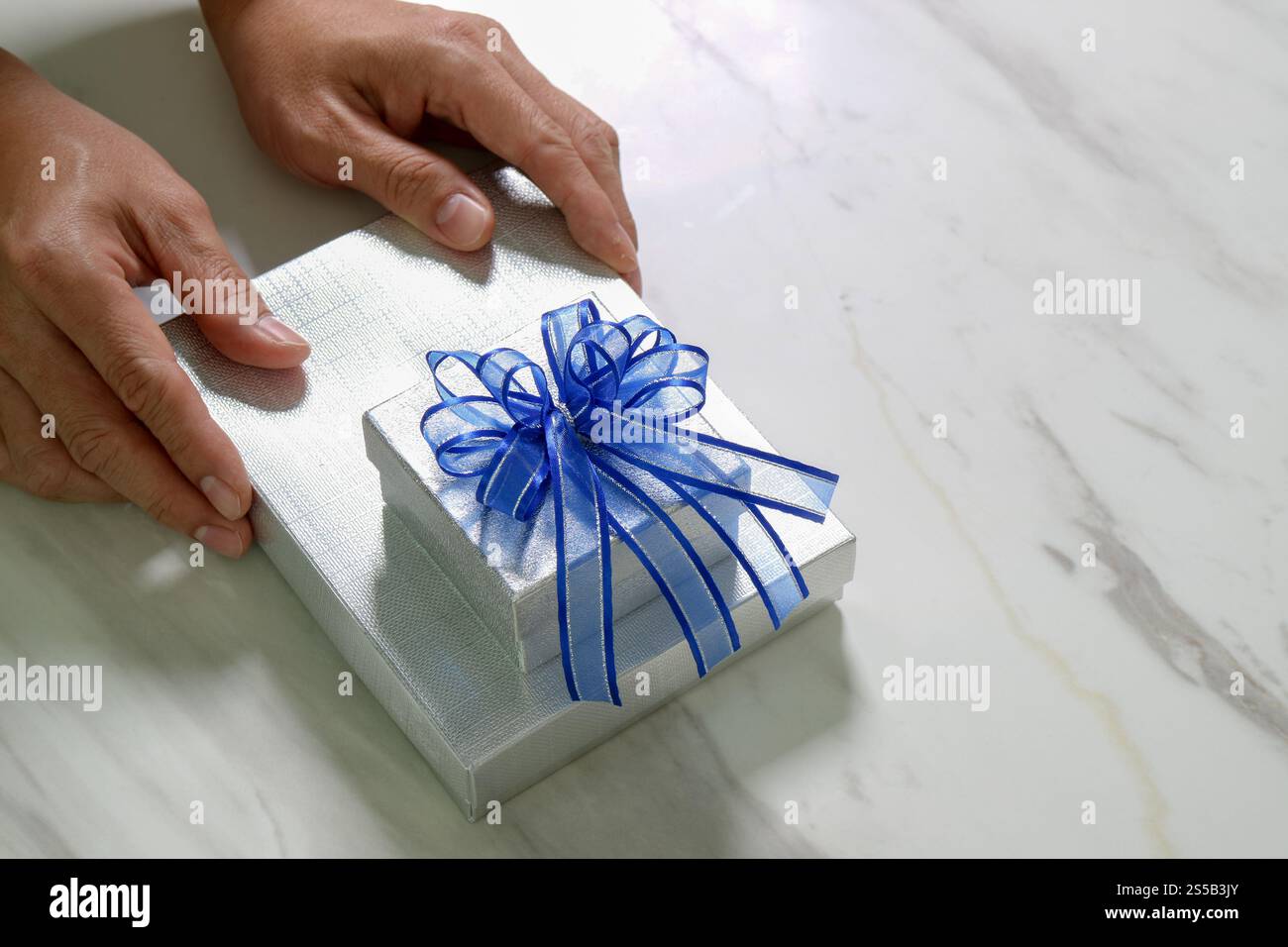 Geschenke, Mann Hand hält eine Geschenkbox in einer Geste der giving.blurred Hintergrund Stockfoto