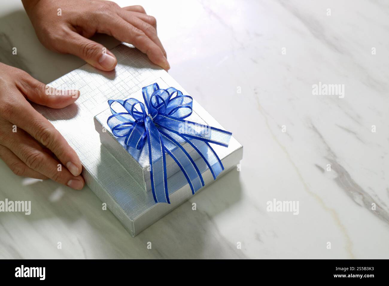 Geschenke, Mann Hand hält eine Geschenkbox in einer Geste der giving.blurred Hintergrund Stockfoto