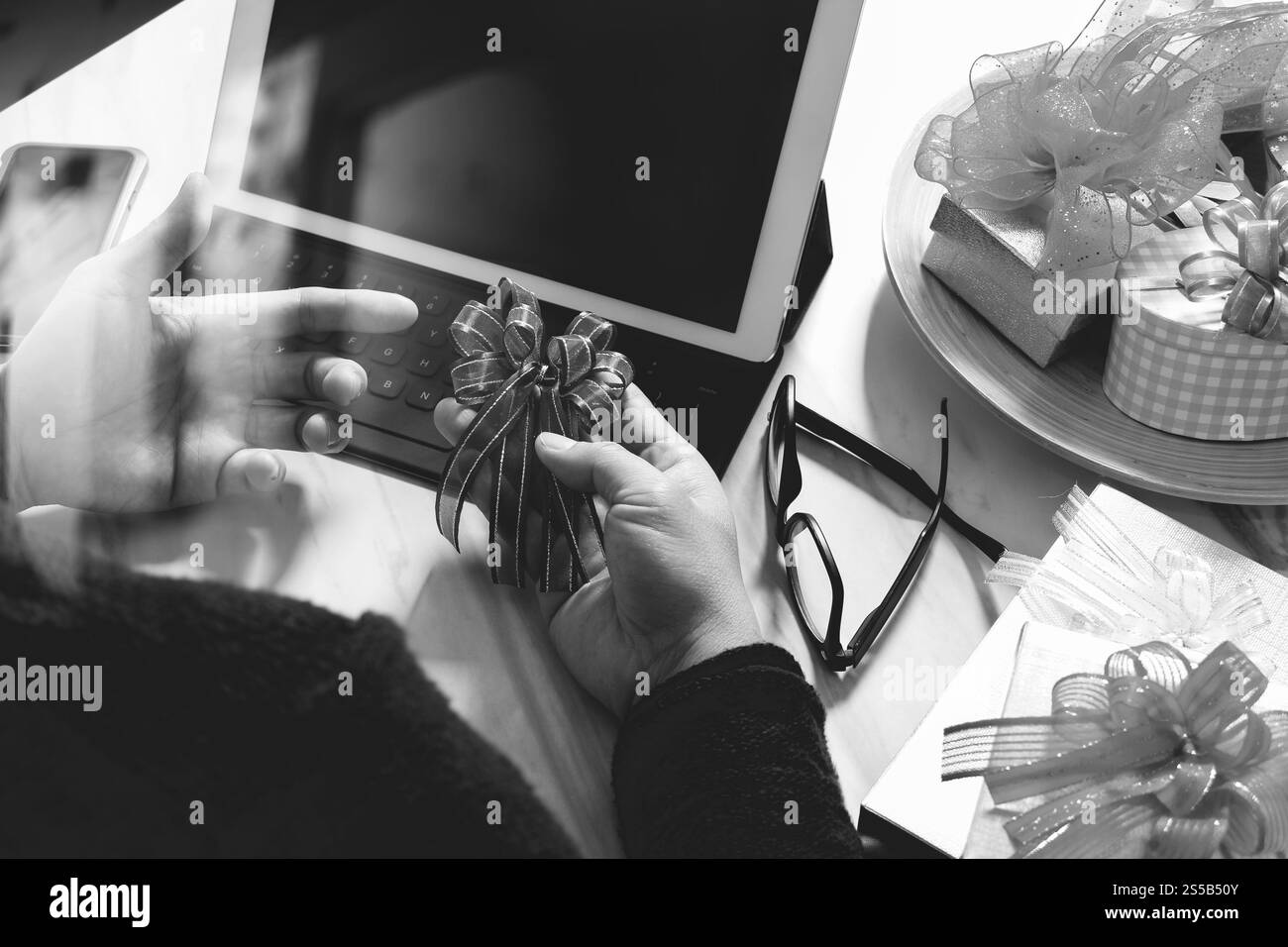 Geschenke Auswahl kreative Hand und Hand mit Geschenk. Geschenk-Lieferung, Überraschung, Tablet PC Docking-smart-Tastatur Smartphone auf Mable Schreibtisch, schwarz Stockfoto