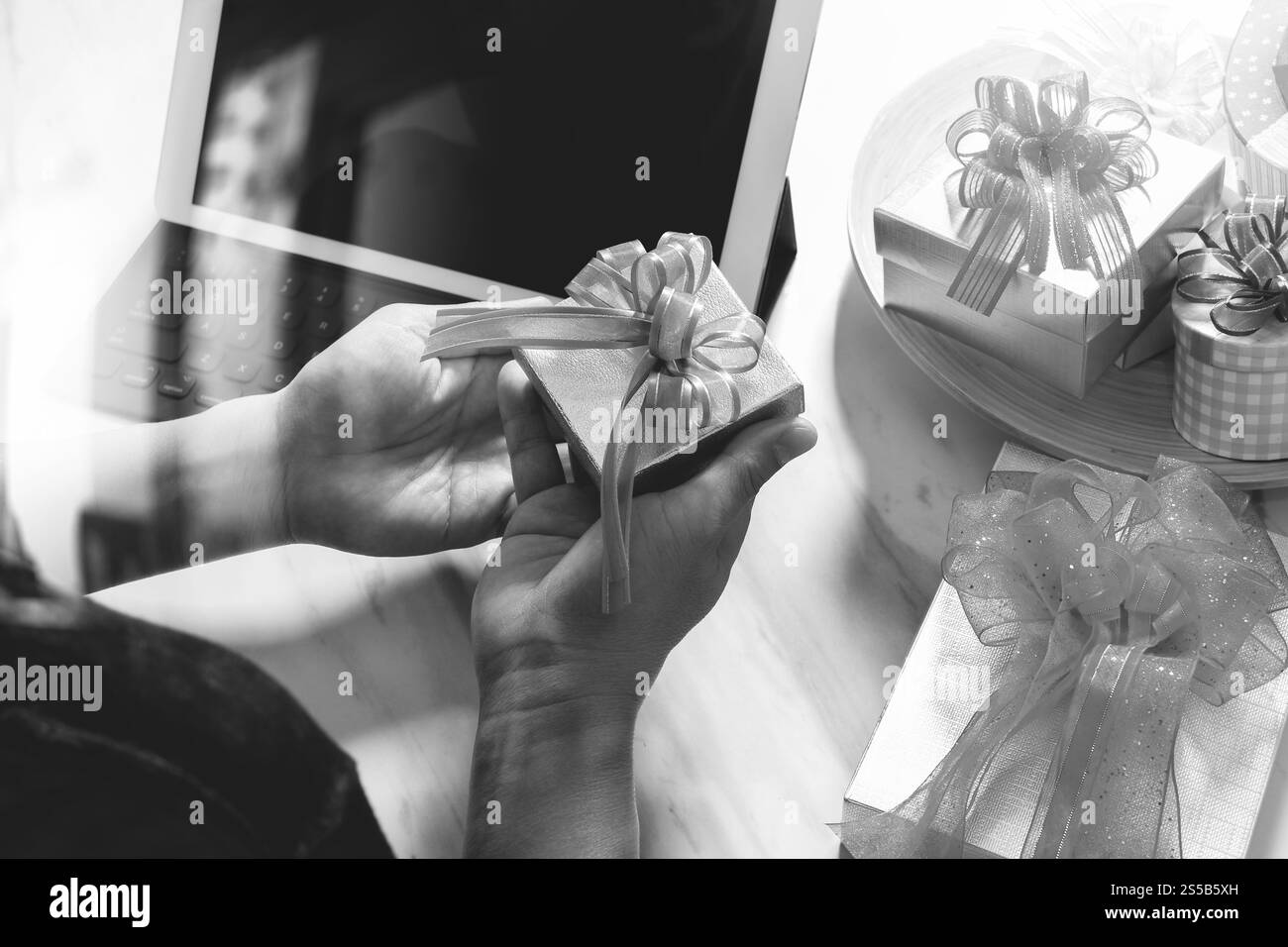 Kreatives Geschenk mit digitalem Tablet-Computer, der Smart Keyboard auf dem Schreibtisch des Mable, schwarz-weiß, andockt Stockfoto