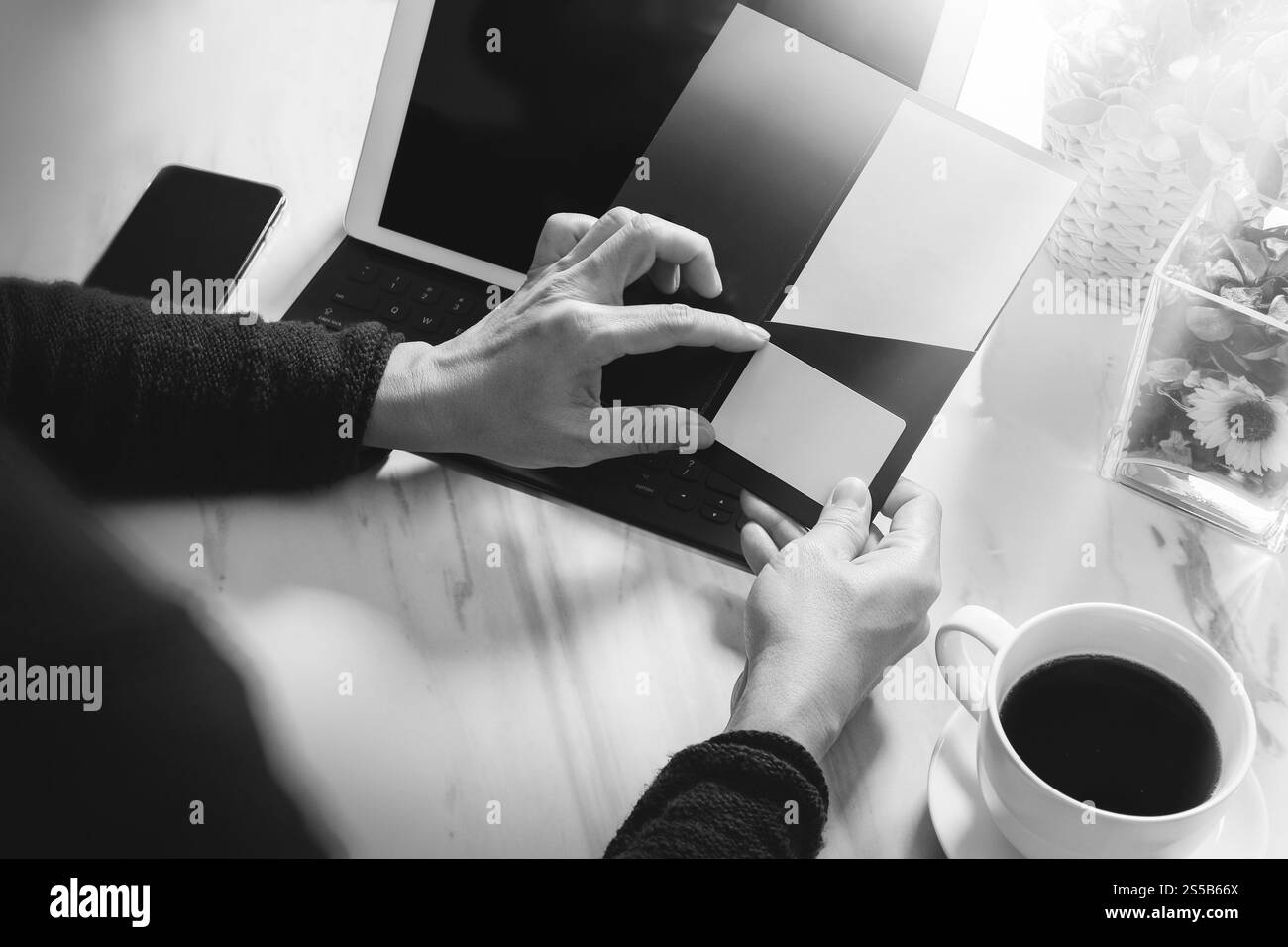 Geschäftsleute Hände halten neue Geschenkkarte oder Kreditkarte, Digital Tablet Computer Dock Tastatur, Smartphone auf Marmorschreibtisch, schwarz weiß Stockfoto