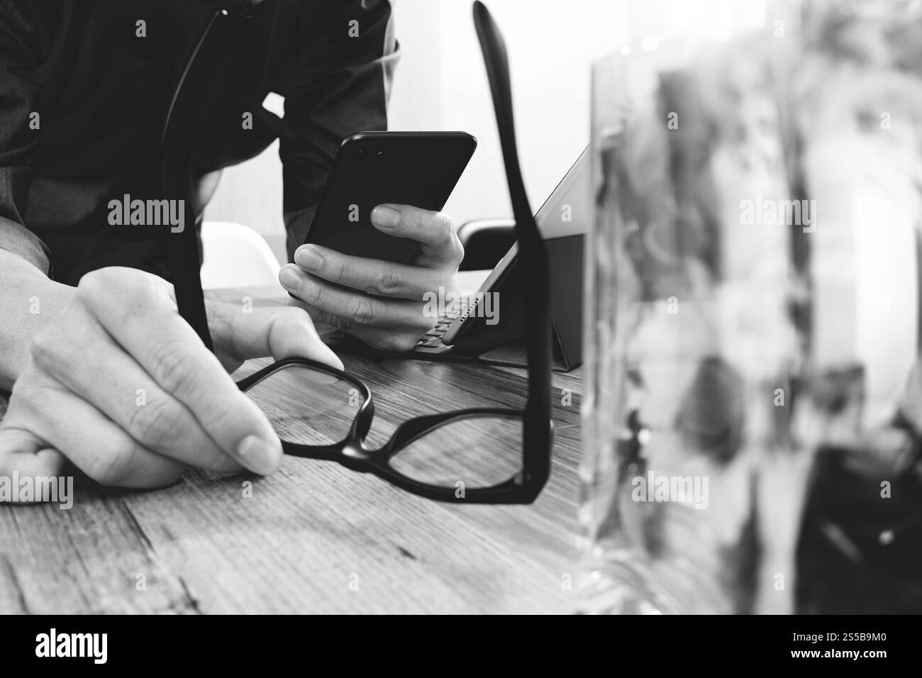 Geschäftsmann Hand mit Brillen mit smart-Phone, mobile Zahlungen online-shopping, Omnichannel, digital-Tablette Docking-Tastatur Computer, Blume Glas Stockfoto